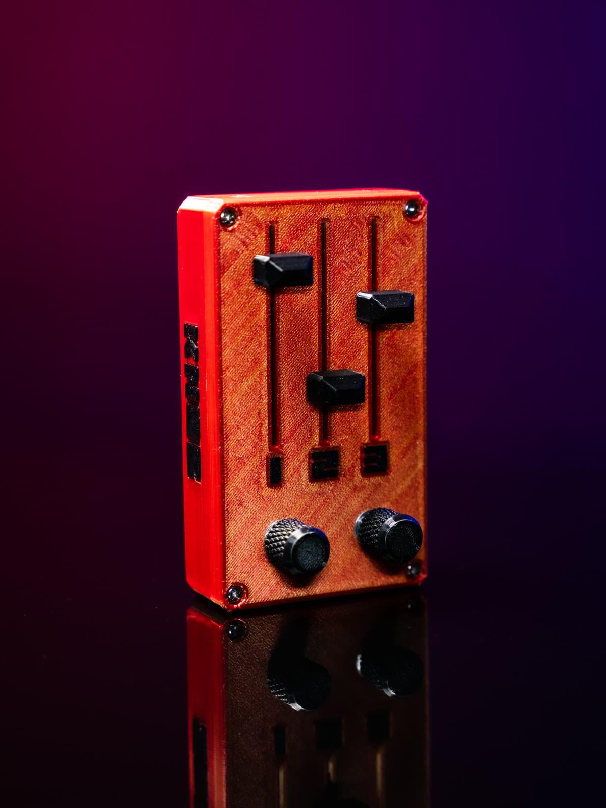 KNOB cobrizo con borde rojo, visto en ángulo sobre fondo rojo y violeta, con reflejo abajo